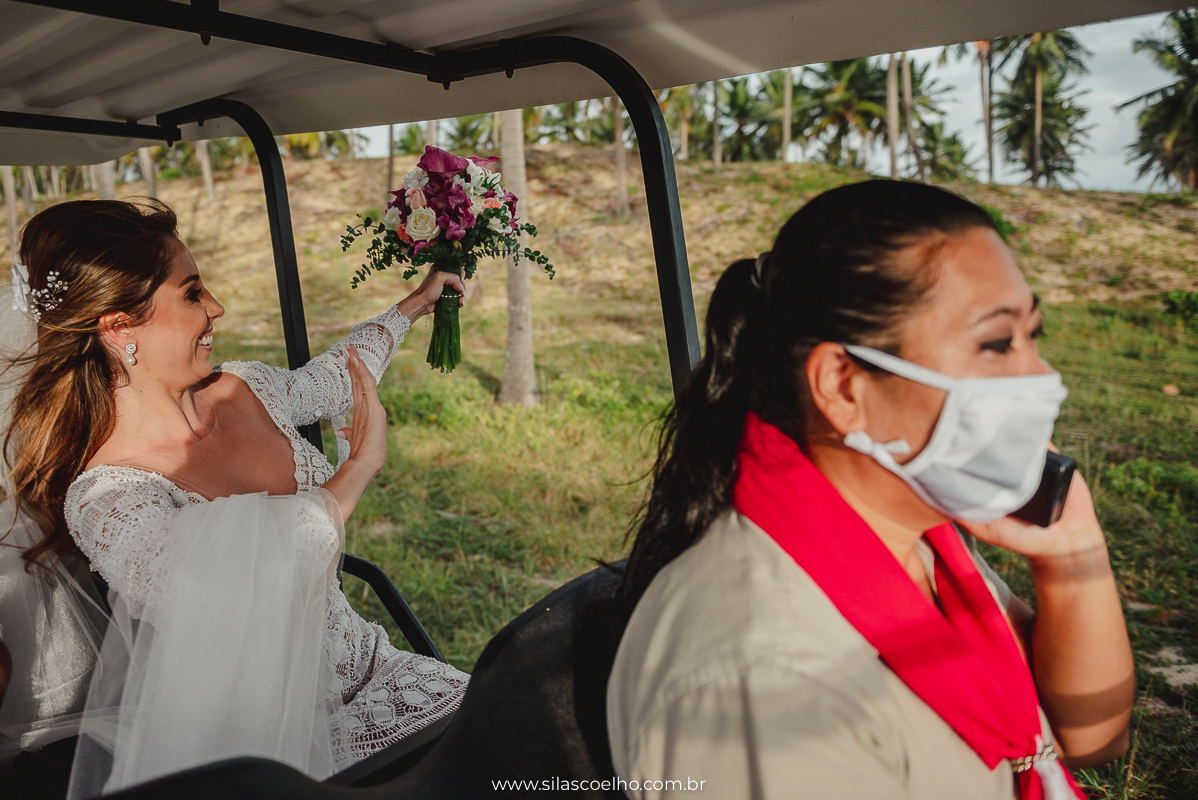 Noiva no carrinho de golf indo para cerimonia ao ar livre em frente ao mar e no por do sol