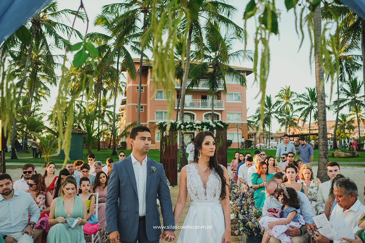 Noiva entrando no casamento na Praia em Costa do Sauípe Bahia no pôr do sol, com pé na areia
