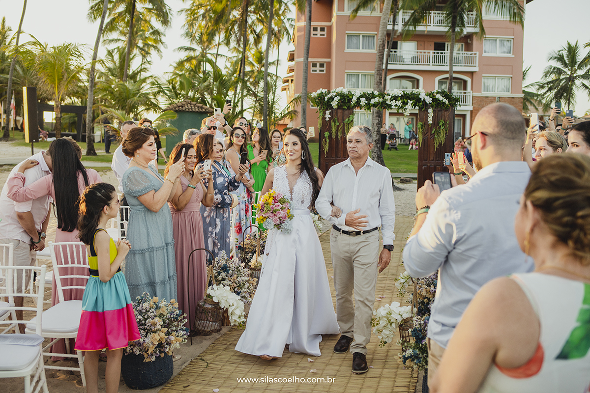 Noiva entrando no casamento na Praia em Costa do Sauípe Bahia no pôr do sol, com pé na areia