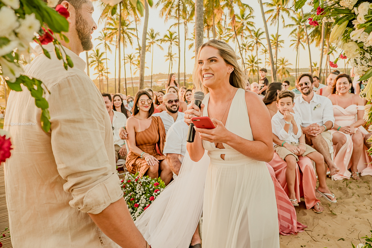 noiva lendo os votos Casamento no grand palladium imbassaí & SPA. casamento na praia, com pé na areia e no pôr do sol. Frente ao mar