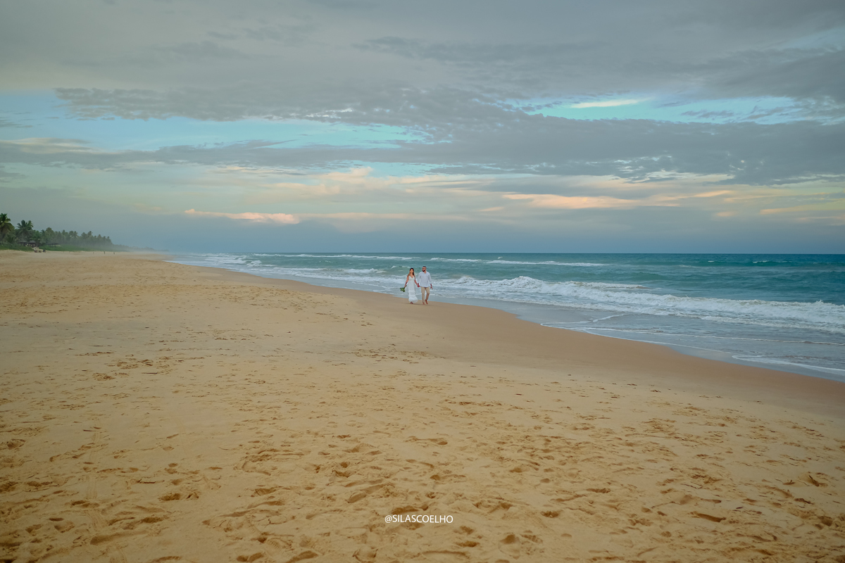 sessão de fotos pós casamento na praia, na bahia, no por do sol, no resort, com pé na areia. noivos caminhando na praia depois do casamento
