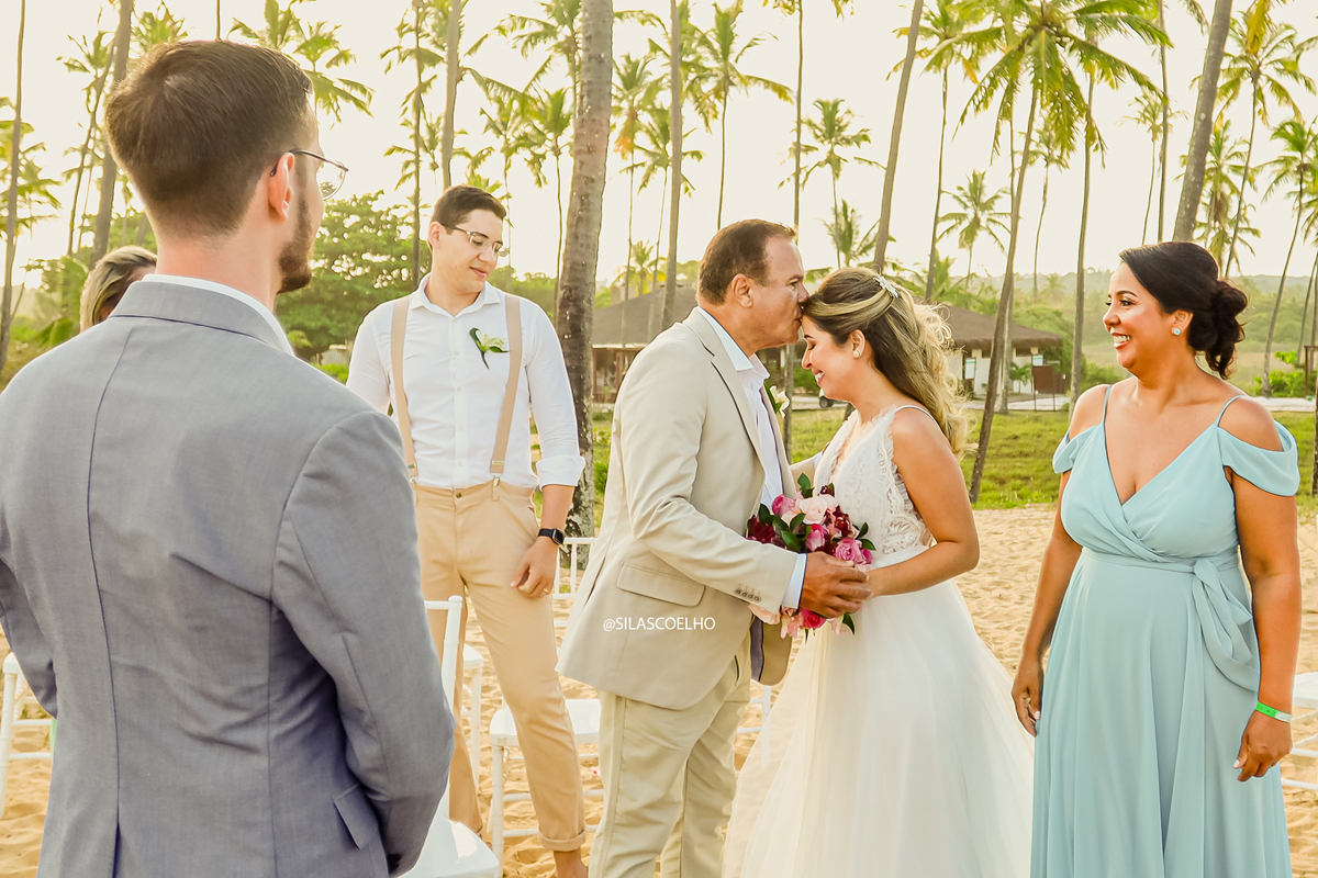 beijo do pai da noiva na entrada da cerimônia no seu casamento na praia do elompmente wedding destination no por do sol e com pé na areia