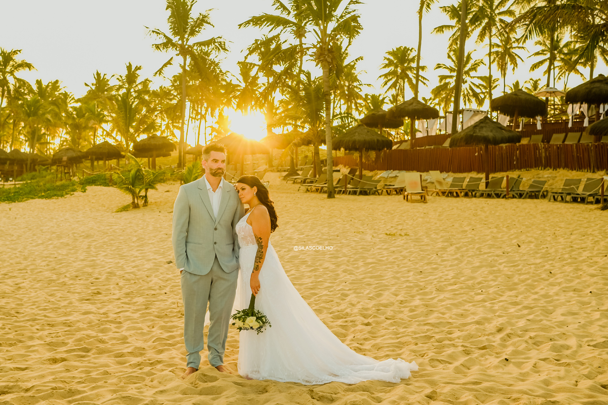 sessão de pós casamento na praia frente ao mar, com pé na areia e no pôr do sol