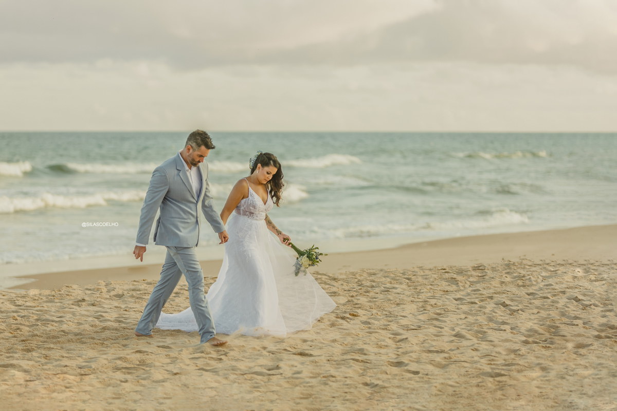 sessão de pós casamento na praia frente ao mar, com pé na areia e no pôr do sol