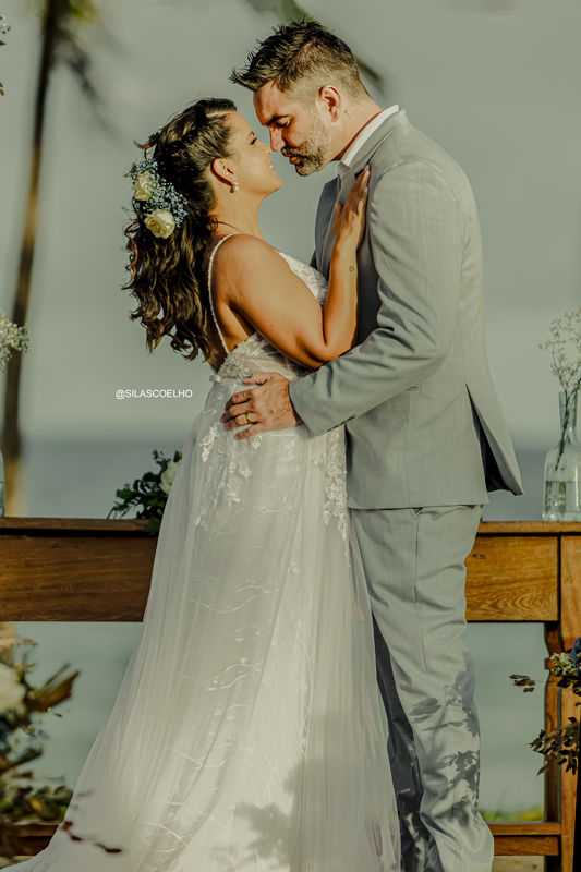 sessão de pós casamento na praia frente ao mar, com pé na areia e no pôr do sol