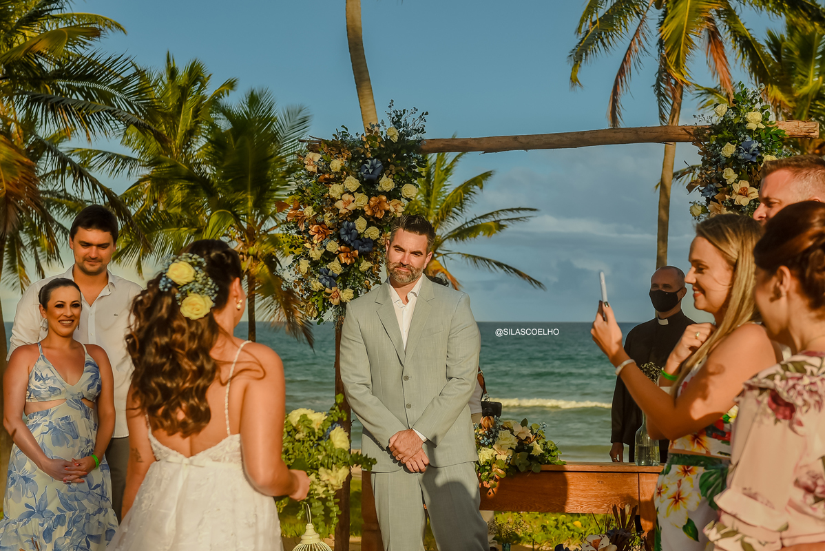 noivo vendo a noiva entrar no casamento na praia frente ao mar na bahia