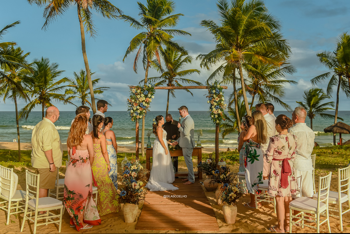 cerimonia de casamento na praia frente ao mar, com pé na areia e no pôr do sol