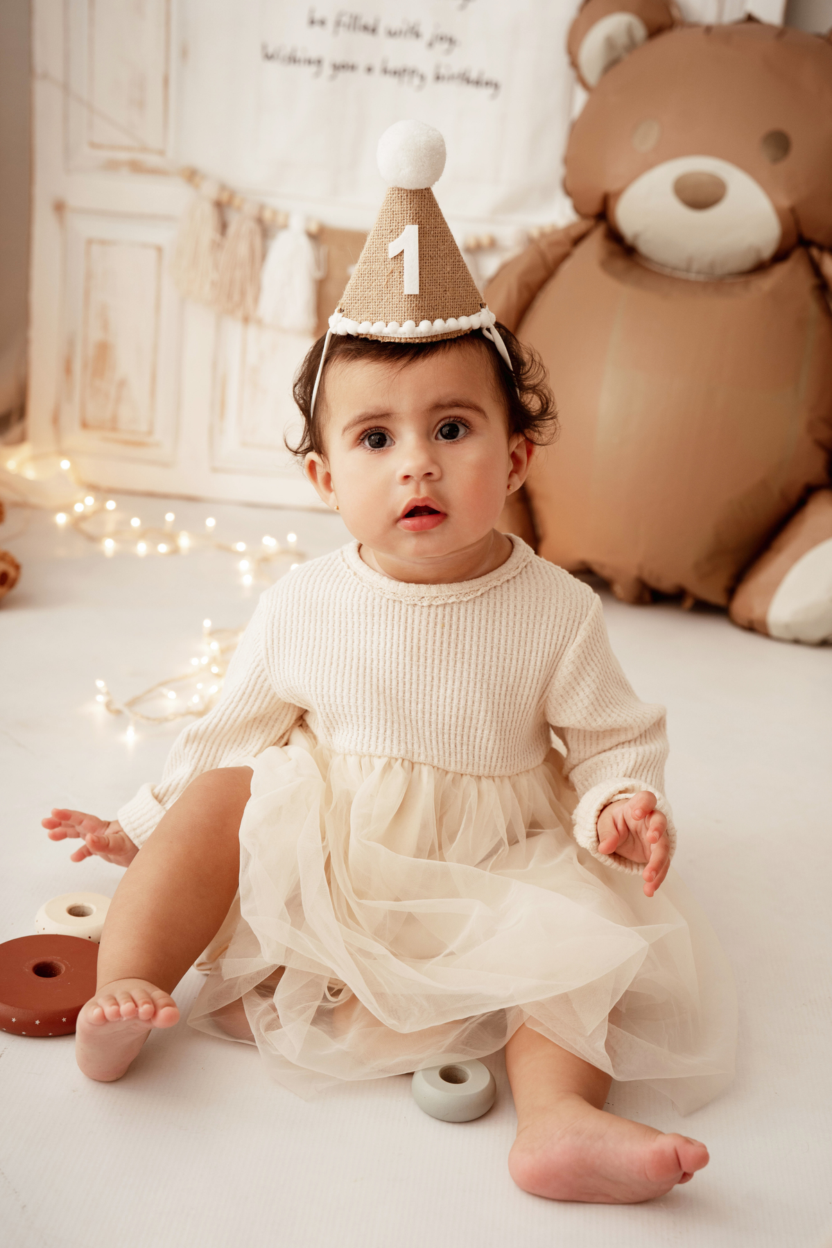 Bebé de 1 ano a explorar bolo de aniversário em sessão fotográfica