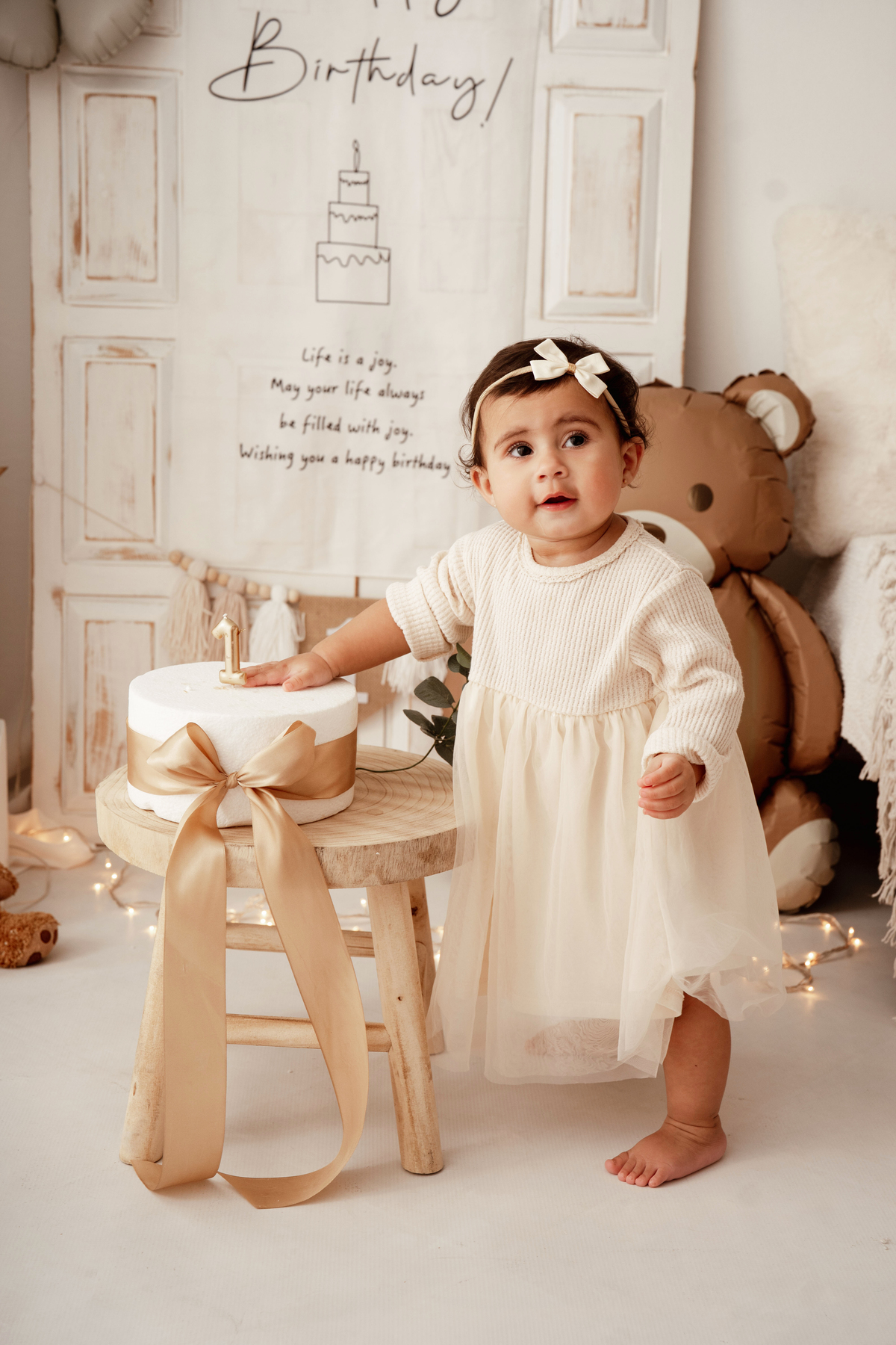 Bebé de 1 ano a explorar bolo de aniversário em sessão fotográfica