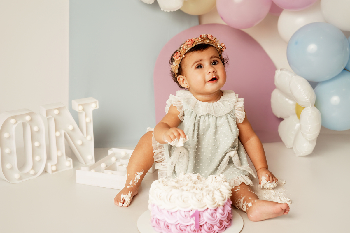 Fotografia de bebé com bolo de 1º aniversário em cenário delicado