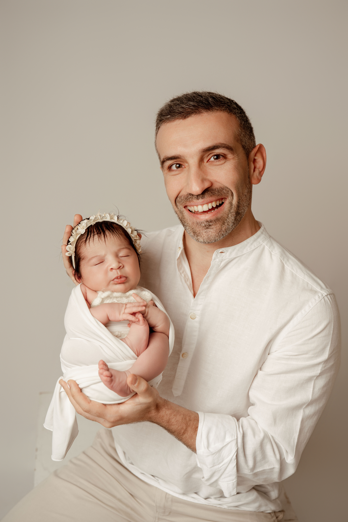 Fotografia de recém-nascido com o pai em estúdio em Lisboa. Momentos simples e emocionais em família.