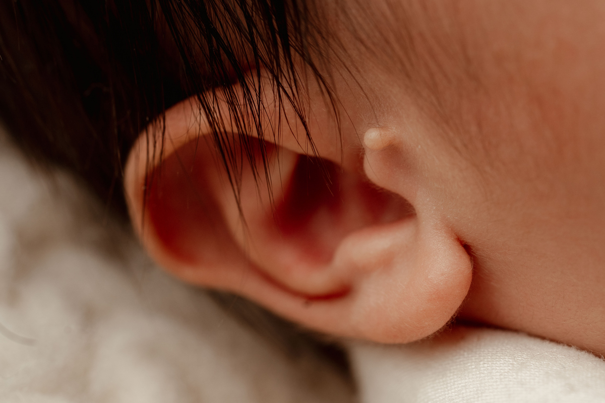 Detalhe da orelha de um recém-nascido durante uma sessão fotográfica newborn em Oeiras. Os pequenos detalhes mudam rapidamente nos primeiros dias de vida.