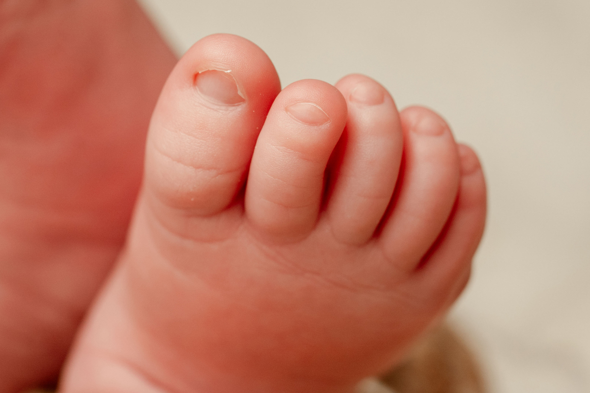 Fotografia de detalhe dos pequenos pés de um recém-nascido. Uma recordação preciosa dos primeiros dias de vida.