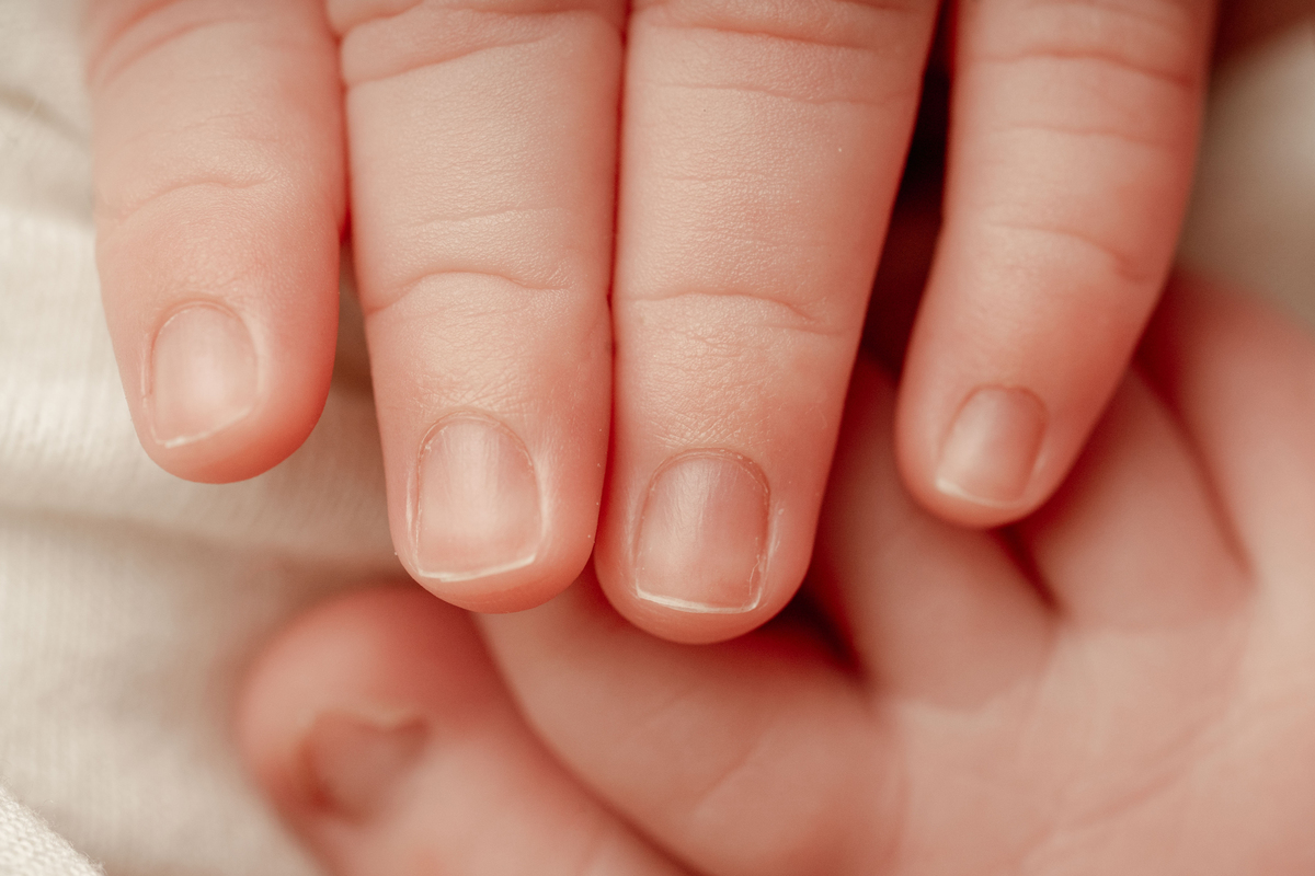 Detalhe das pequenas mãos de um recém-nascido. Os primeiros dias passam depressa e merecem ser recordados.
