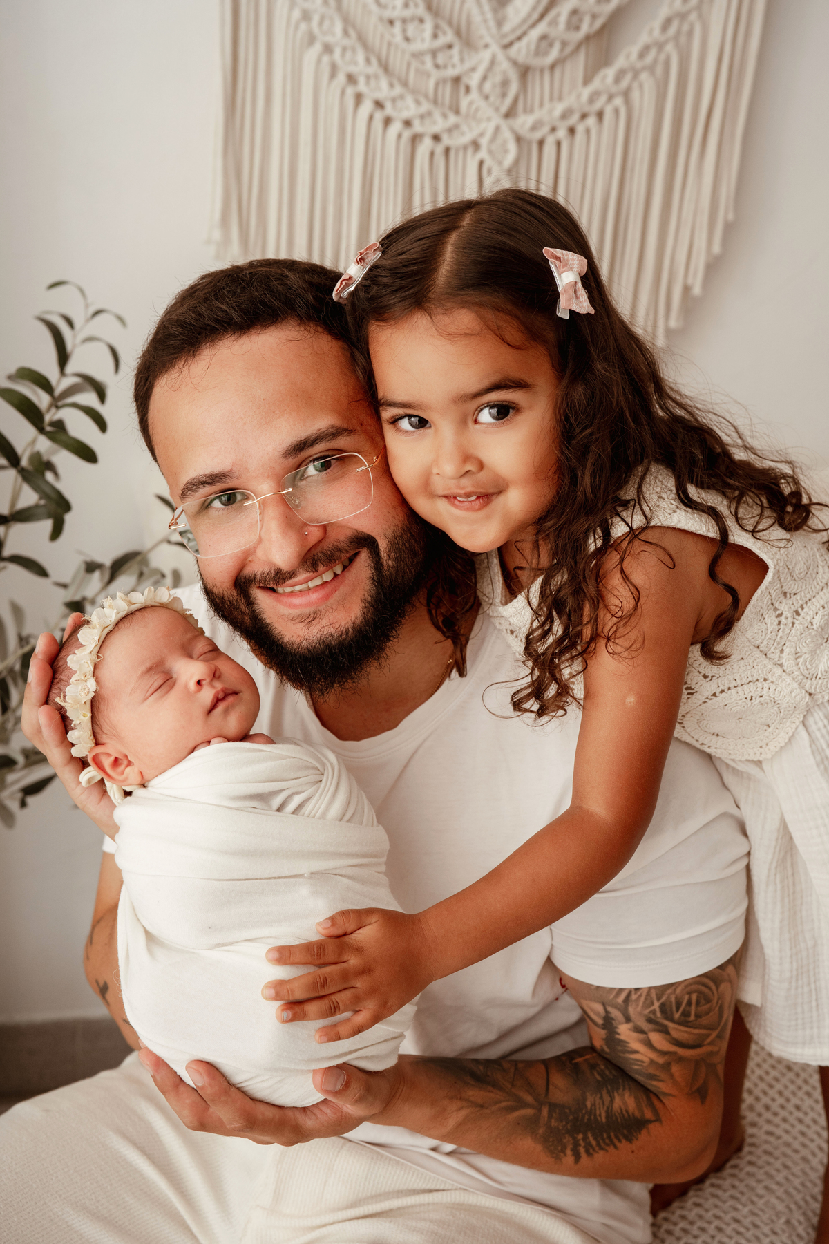 Pai com as duas filhas durante sessão fotográfica de recém-nascido em Lisboa.
