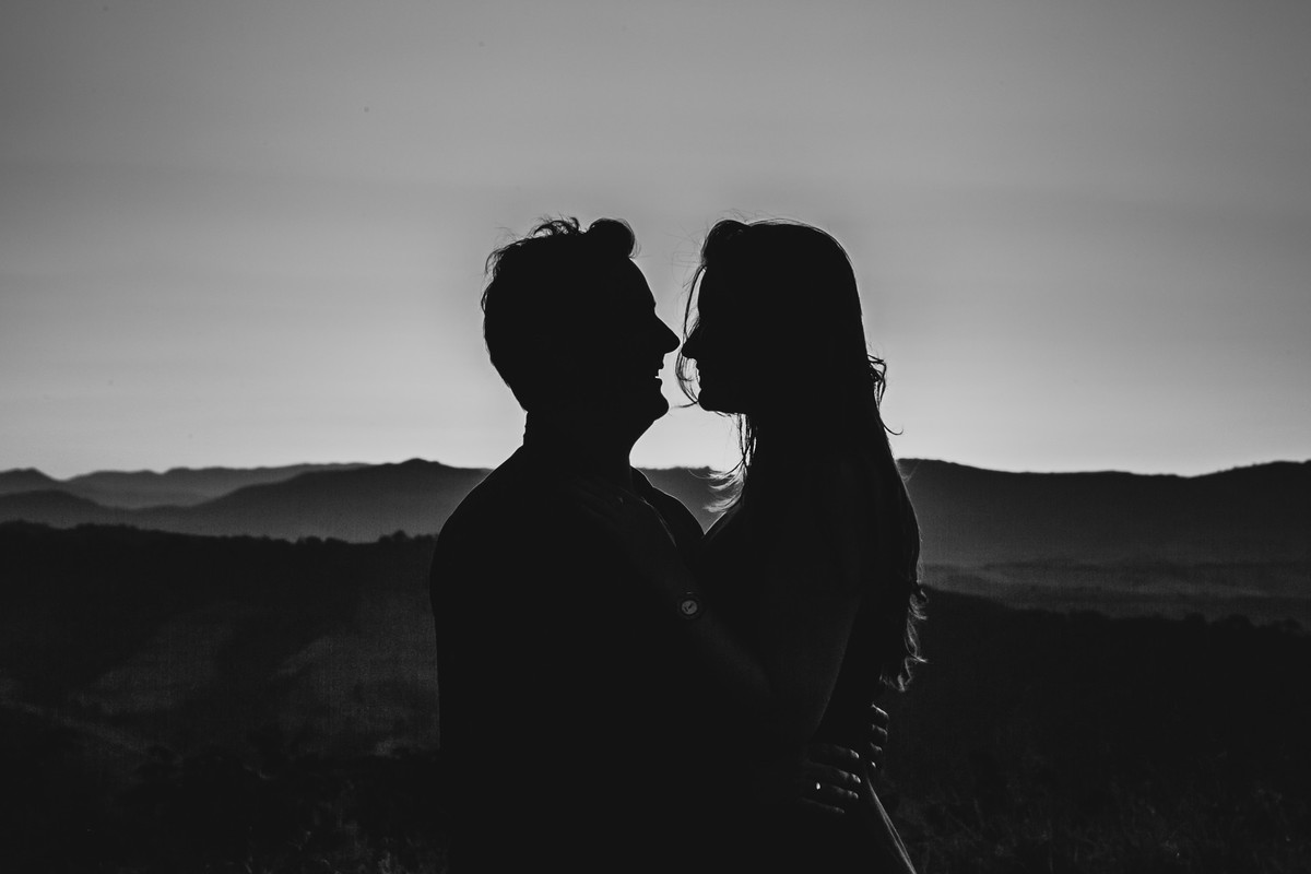 Um casal, no por do sol em cima de uma montanha, vestido roupas brancas. Golden hour na montanha Sagrada em Minas Gerais, na cidade de São Lourenço, pelo fotógrafo Marco Brozzo
