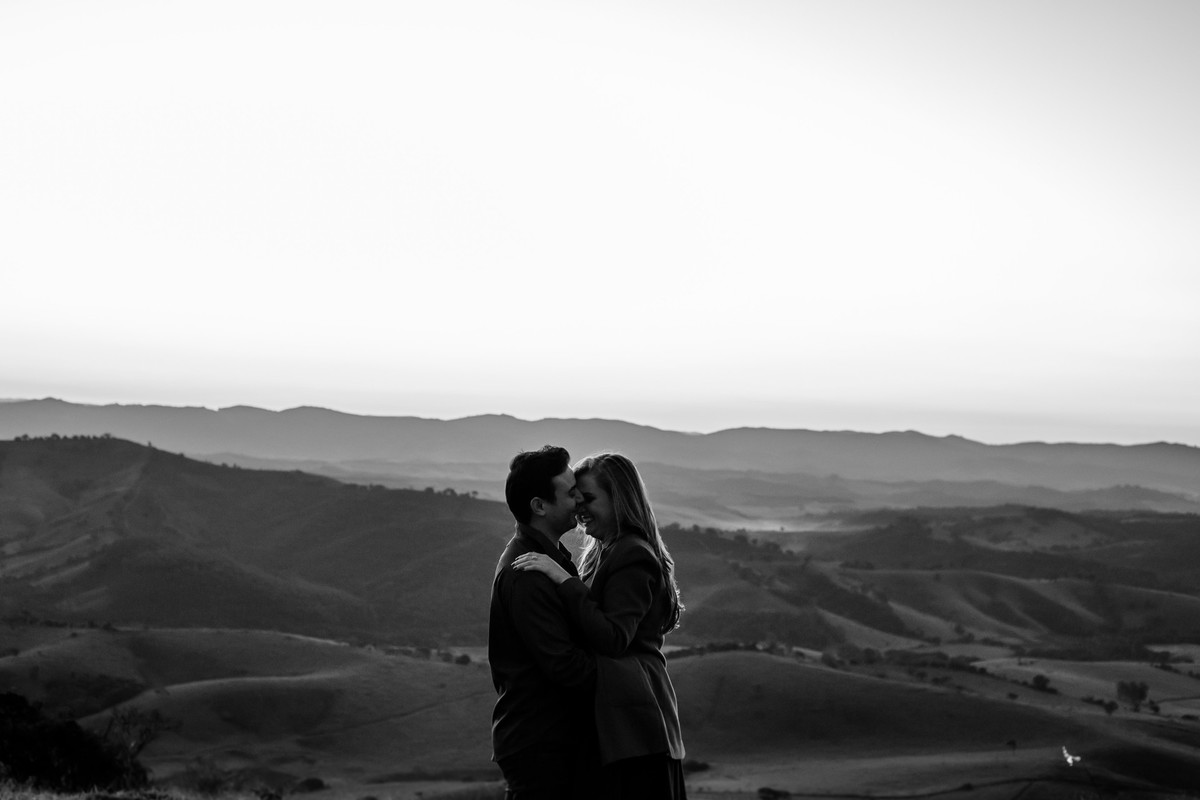 Um casal, no por do sol em cima de uma montanha, vestido roupas brancas. Golden hour na montanha Sagrada em Minas Gerais, na cidade de São Lourenço, pelo fotógrafo Marco Brozzo
