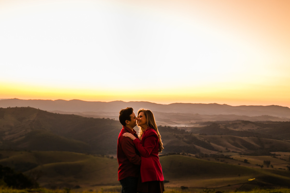 Um casal, no por do sol em cima de uma montanha, vestido roupas brancas. Golden hour na montanha Sagrada em Minas Gerais, na cidade de São Lourenço, pelo fotógrafo Marco Brozzo