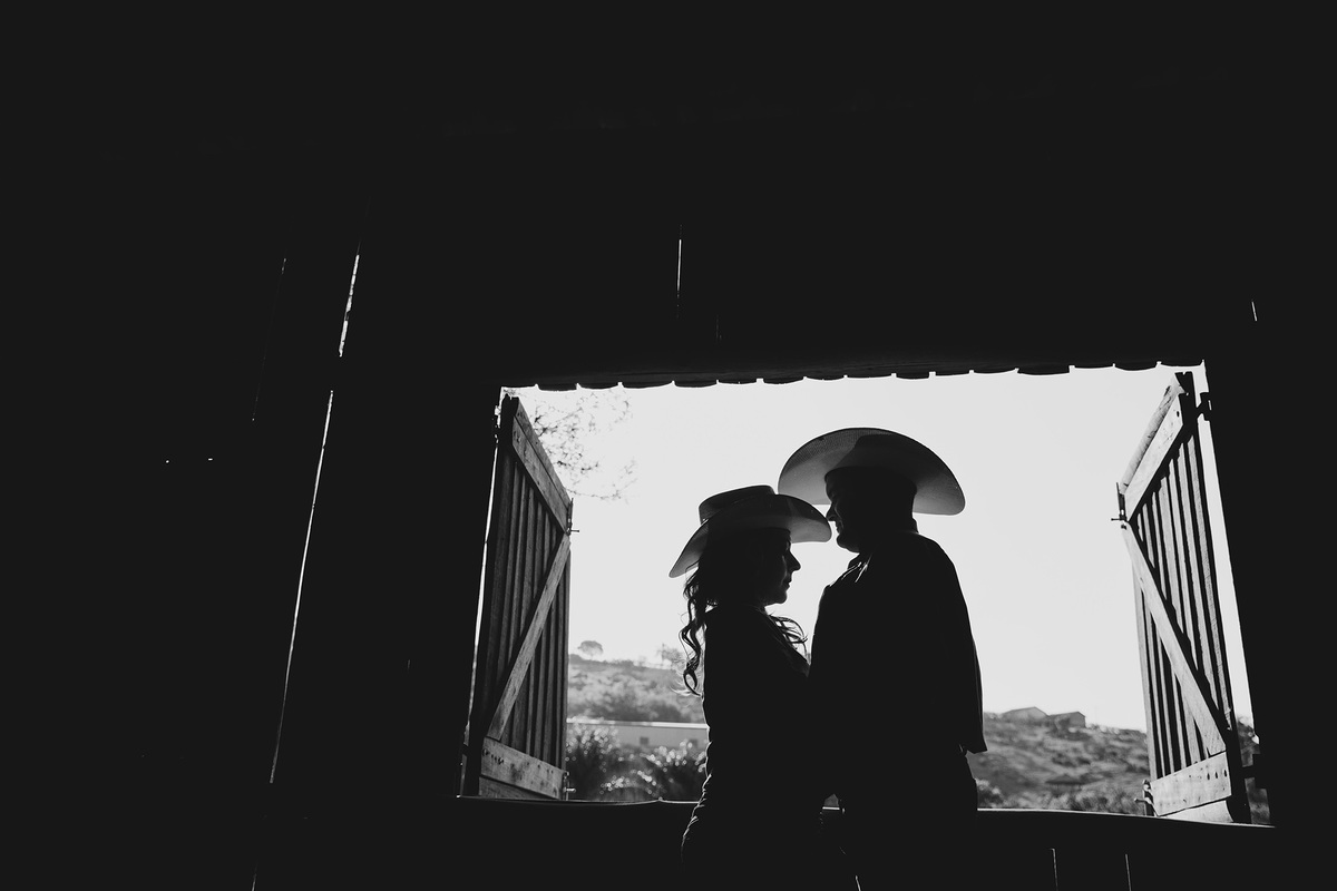 foto de silueta de casal de noivos em janela em barracao na fazenda fotografia preto e branco