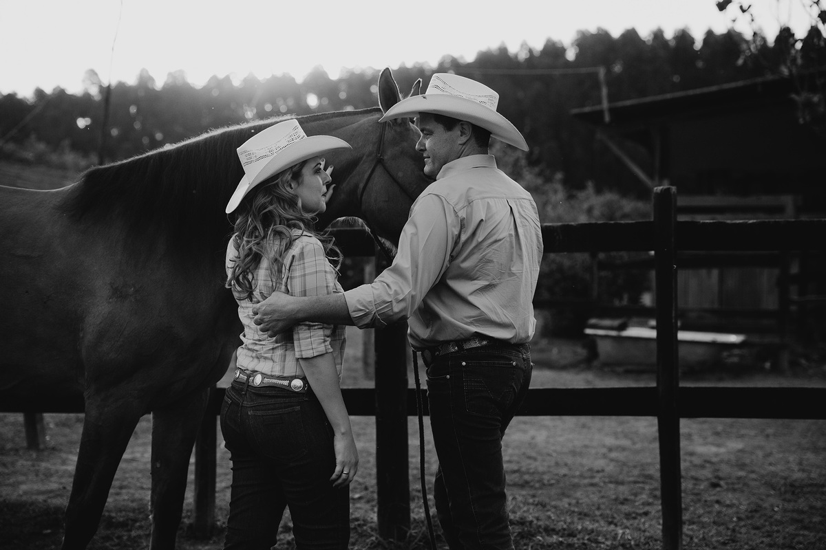 casal na fazenda em foto preto e branco ao lado de cavalo