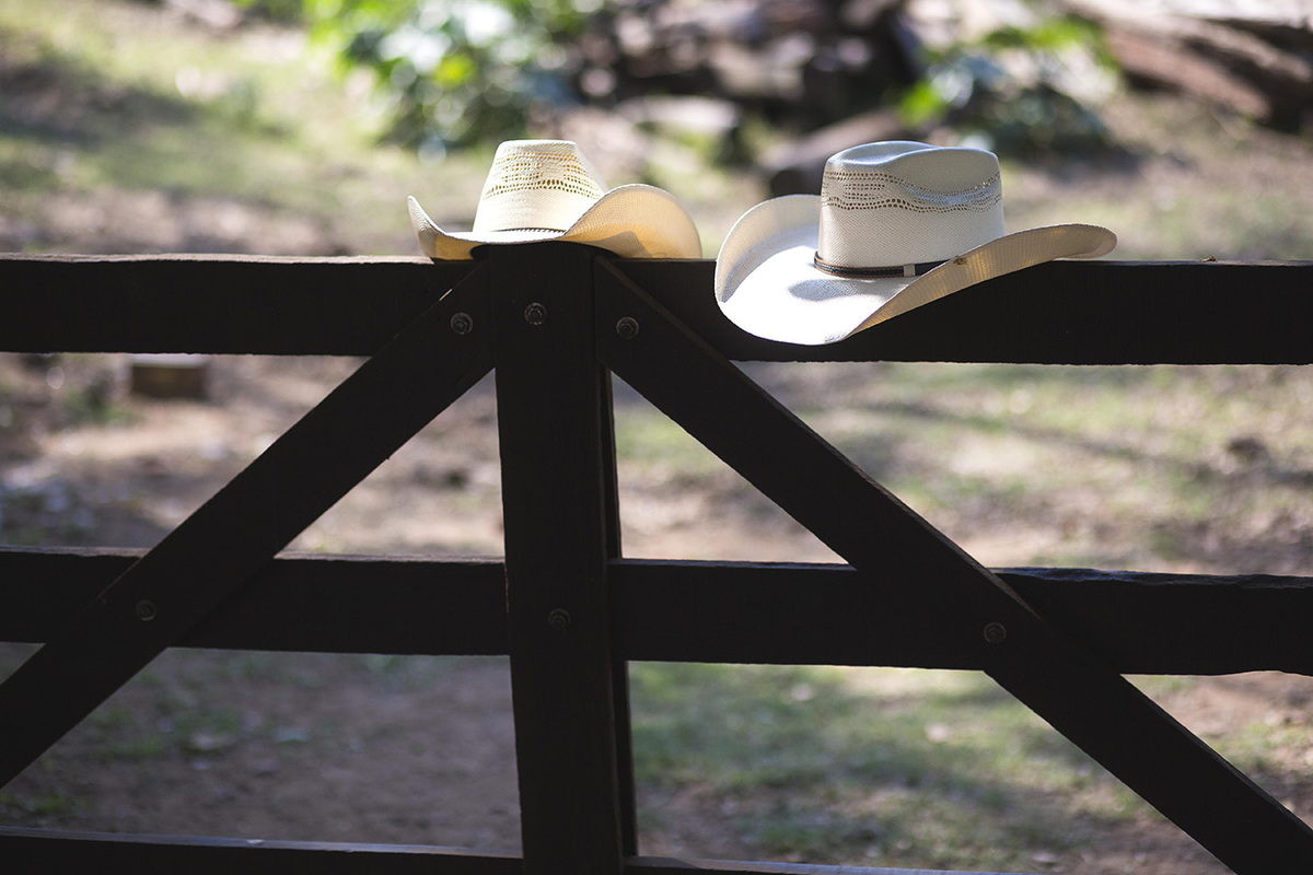 chapeus dos noivos na cerca em fazenda