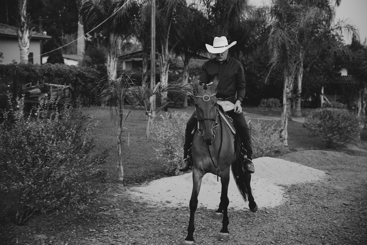 noivo junior montando a cavalo em fazenda fotografia em preto e branco