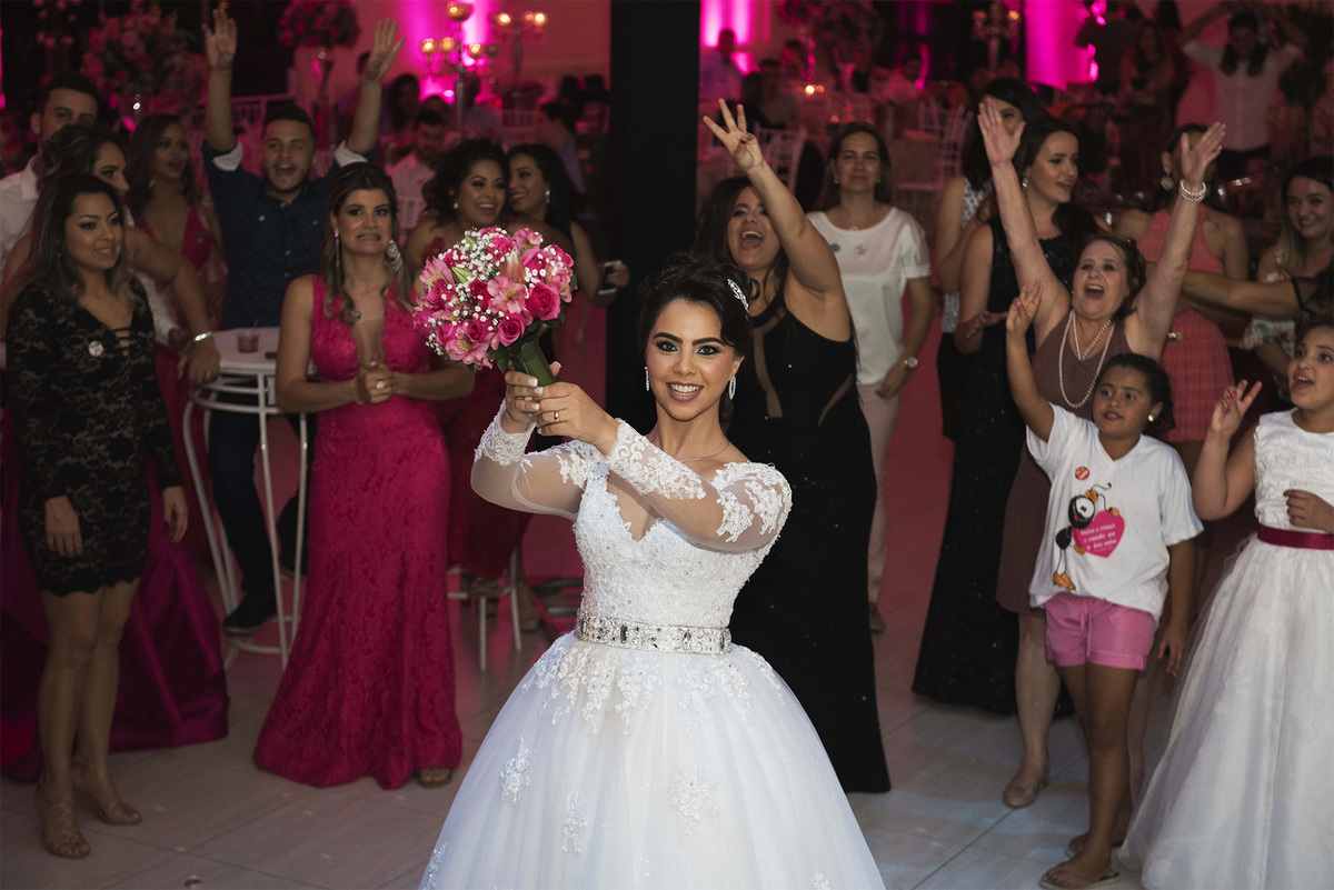noiva jogando o buque para mulheres em casamento