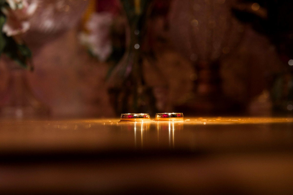 foto criativa das alianças na mesa em casamento
