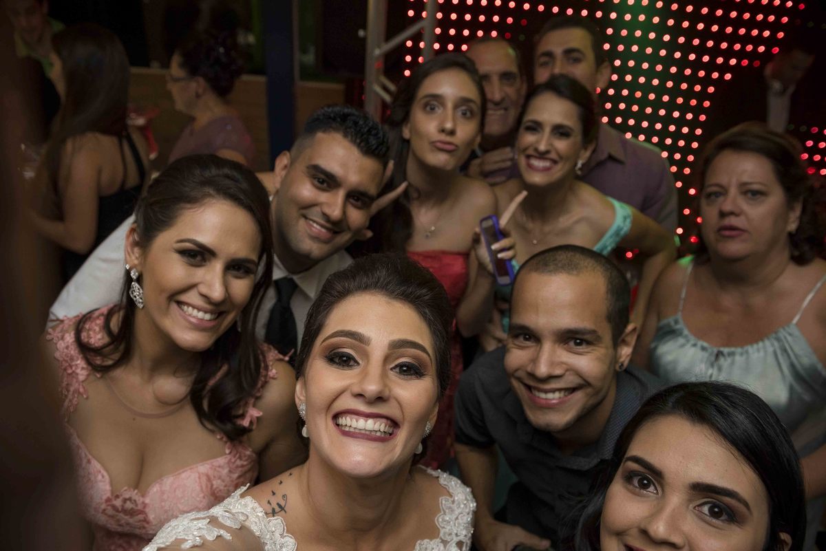 noiva faz selfie com camera com padrinhos