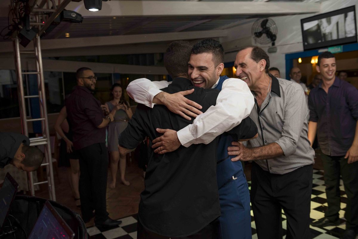 noivo abraça padrinho na pista de dança