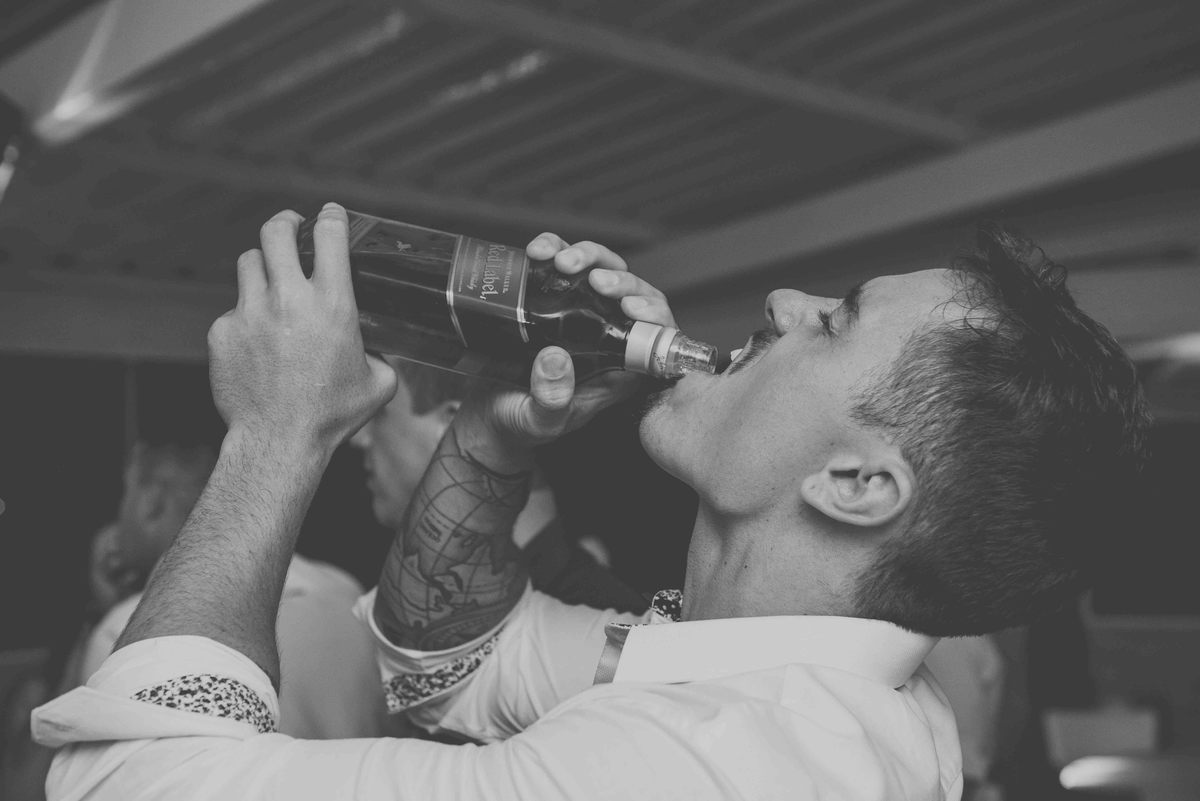 padrinho bebendo whisk red label na festa fotografia preto e branco