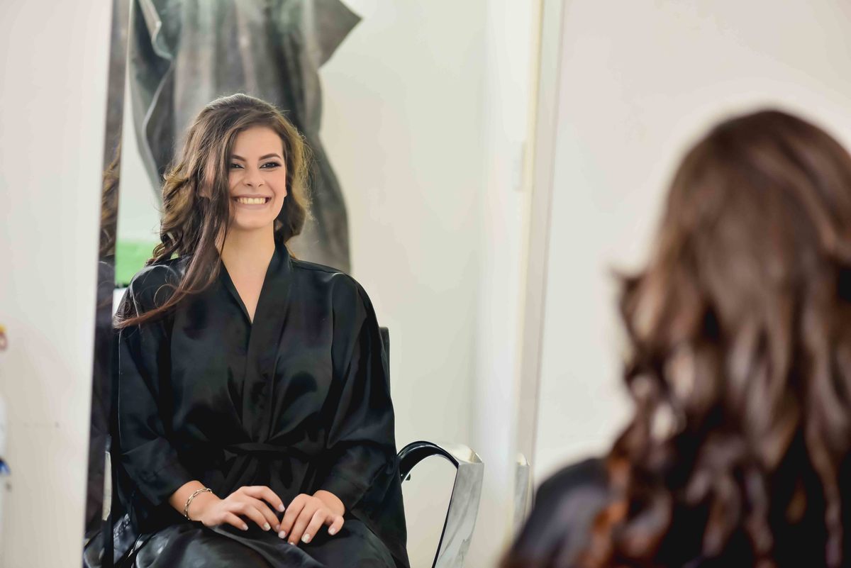 noiva leticia no espelho sorrindo em making of