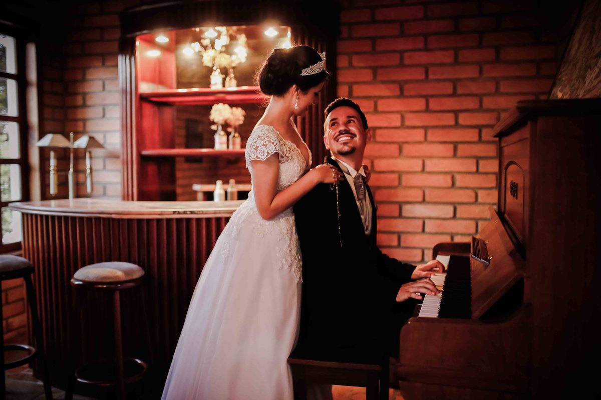noivo marcus no piano sorrindo com a noiva leticia