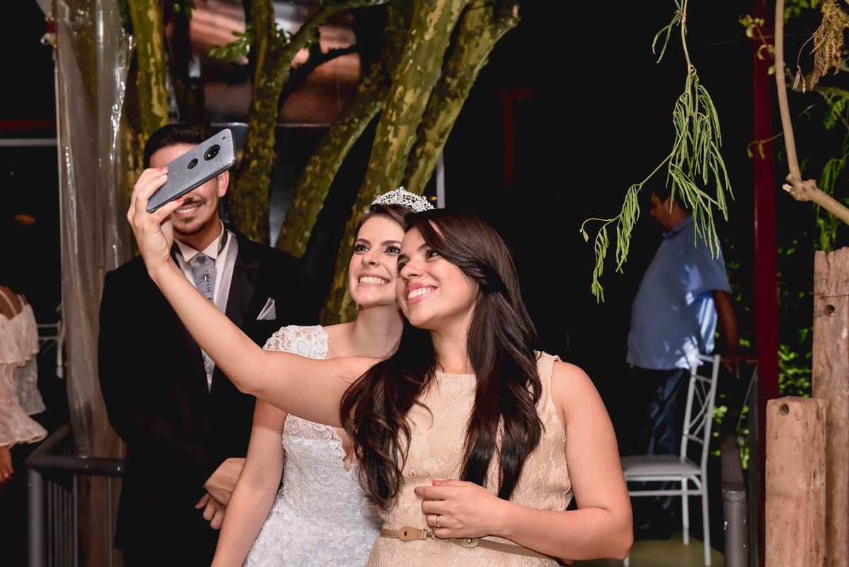 madrinha faz selfie de celular com a noiva