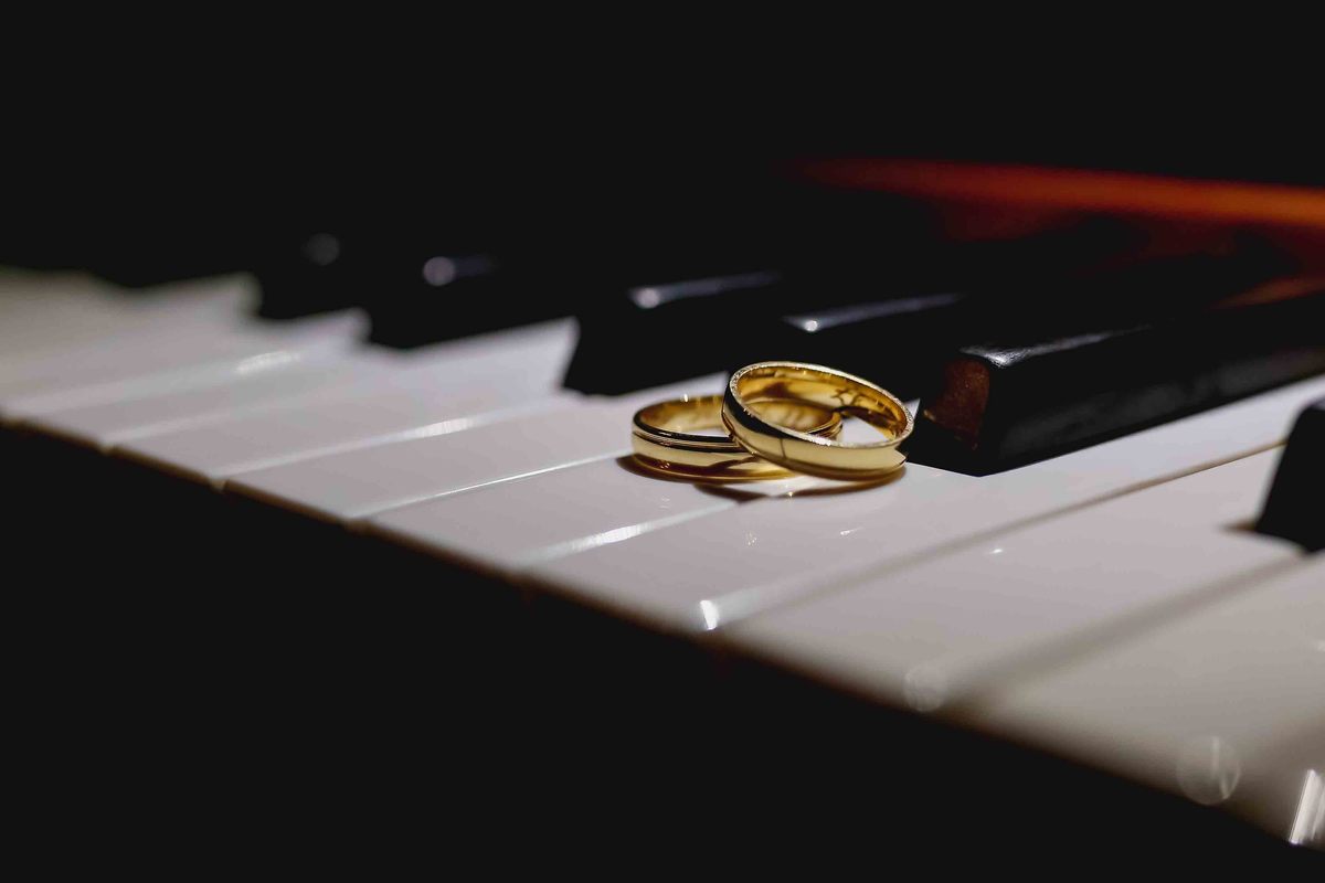 fotografia criativa das alianças dos noiva sobre piano