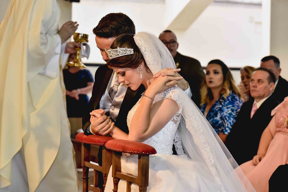 noivos de joelhos em altar