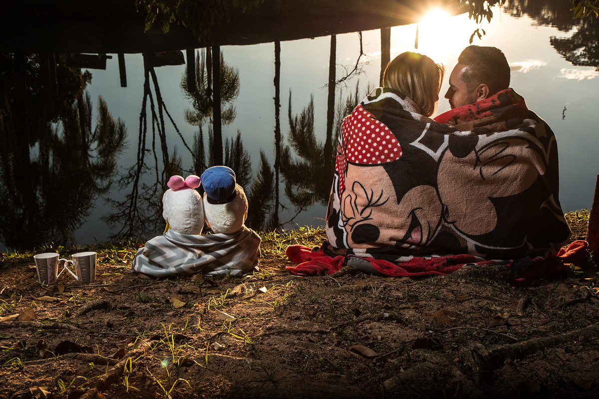 casal de noivos sentados com cobertor e por do sol