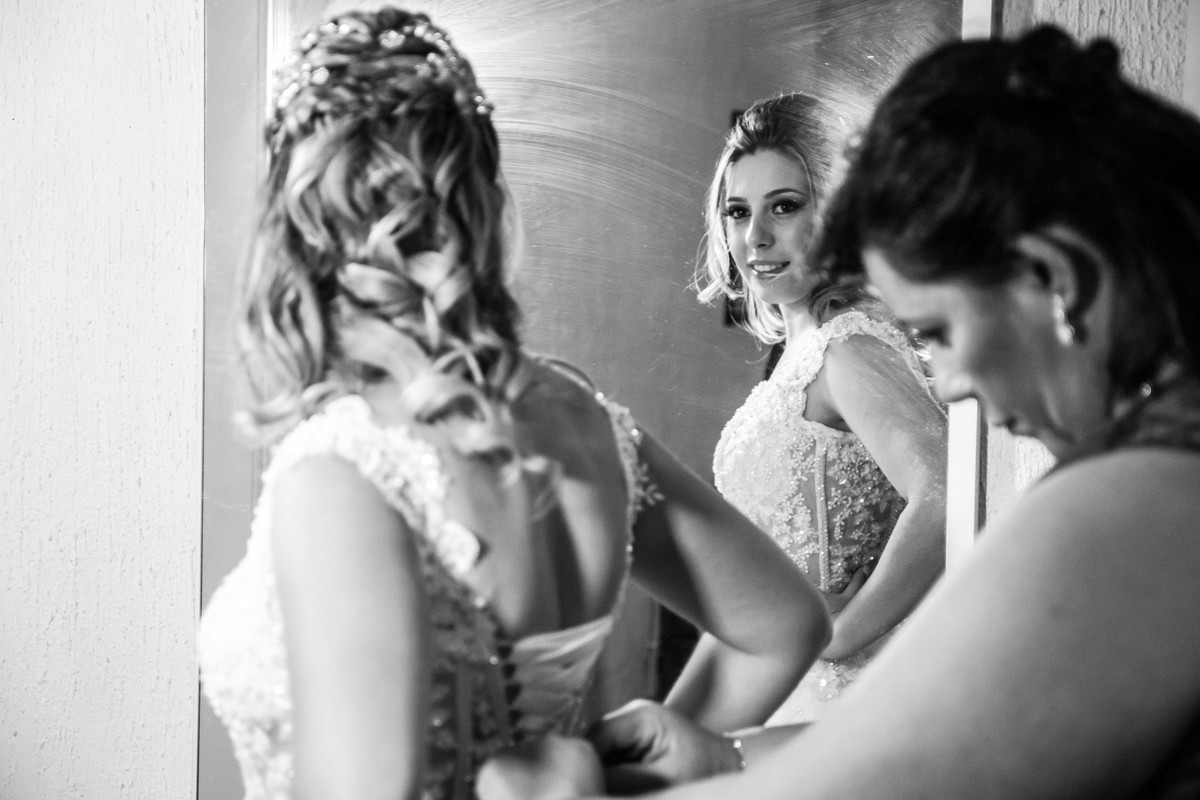 mãe da noiva colocando o vestido