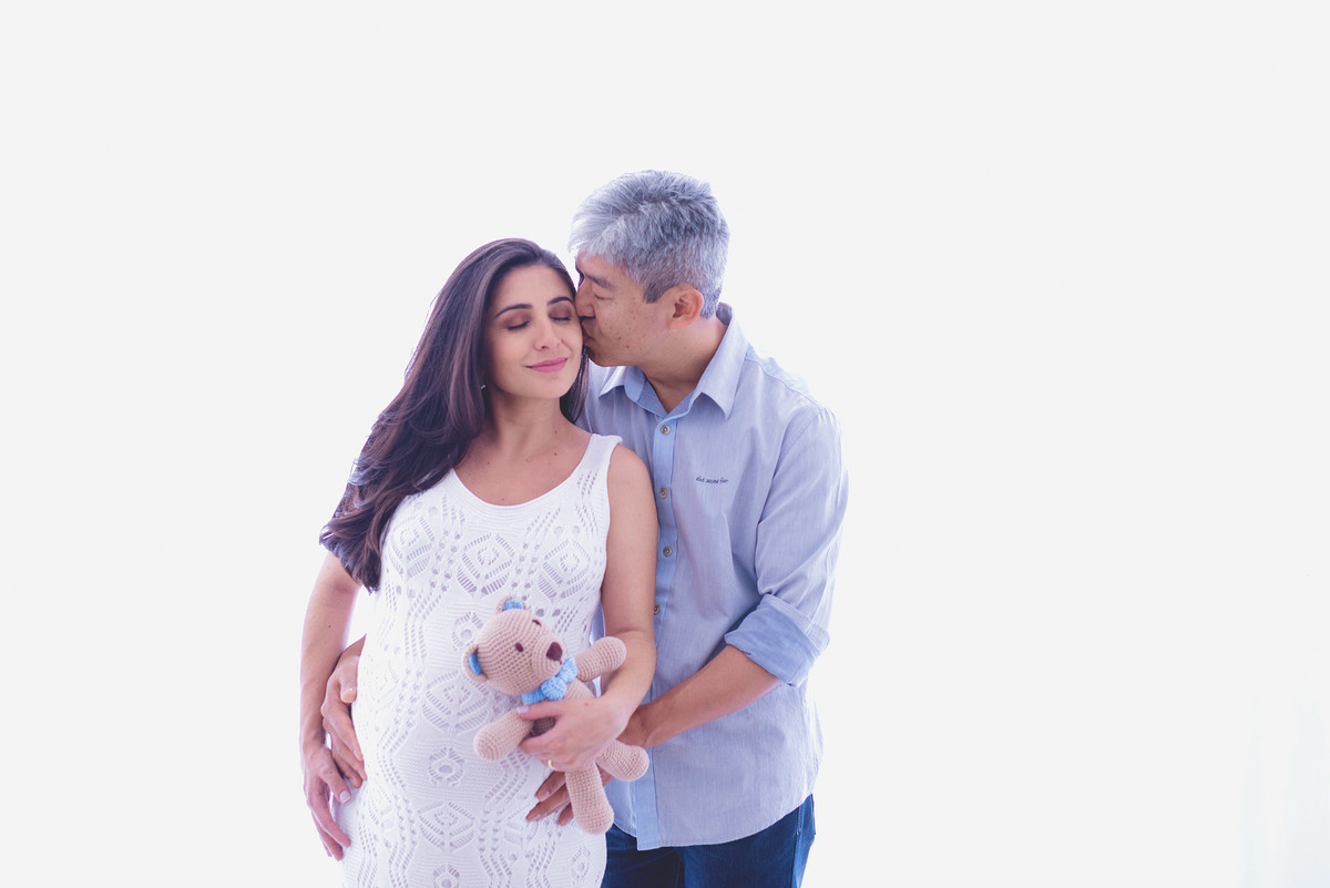 Ensaio gestante em estúdio - fundo branco - vestido branco com ursinho e beijinho do papai