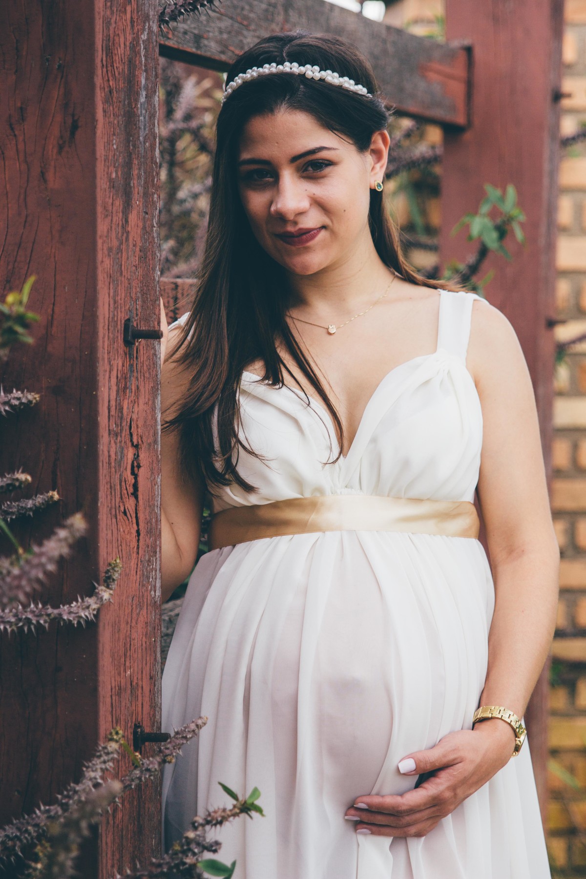 fotografia de gestante em que a mãe esta escorada em um muro