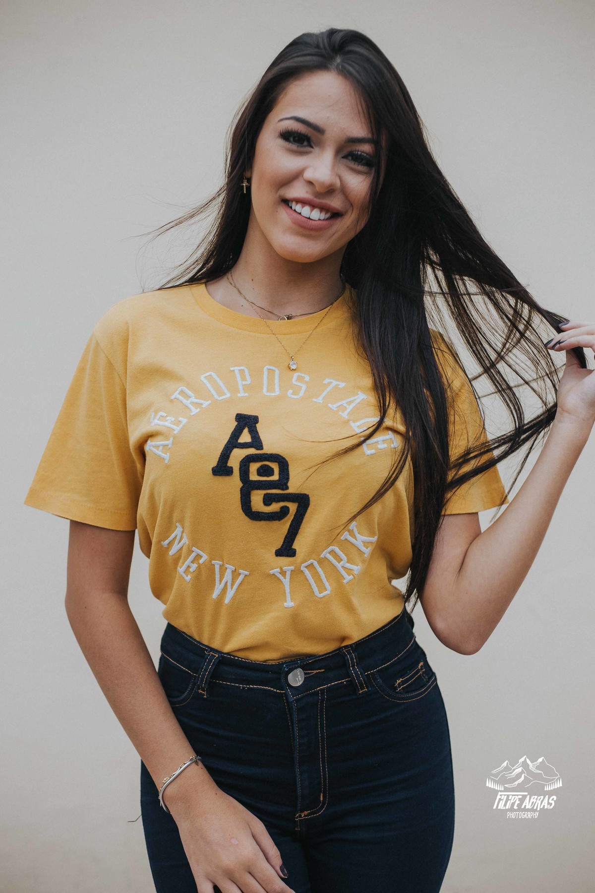 fotografia feminina em que a Livia Melo esta mexendo no cabelo e sorrindo para o fotografo de ensaios femininos