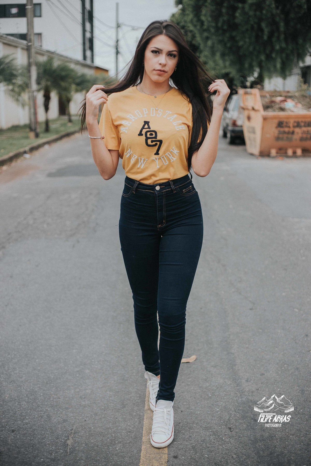 Modelo caminhando pela rua e mexendo no cabelo em um ensaio fotografico estilo street