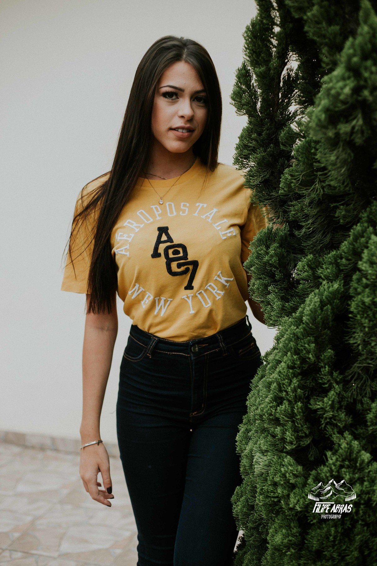 fotografia feminina em que a modelo esta encostada em um pinheiro em uma fotografia estilo tumblr