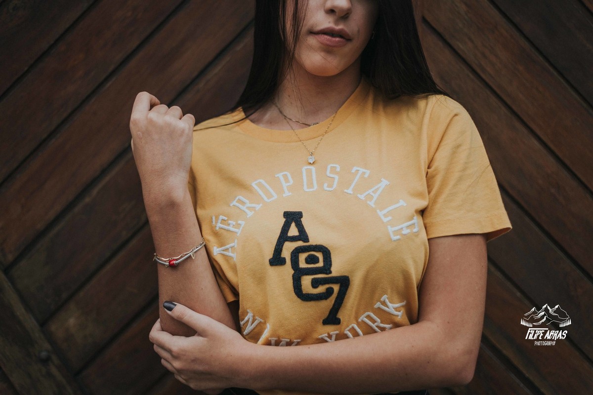 retrato feminino em que a modelo esta segurando seus braços em um enquadramento criativo