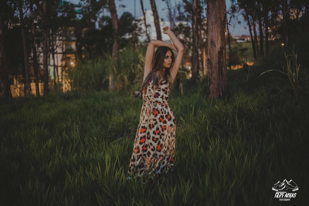 ensaio feminino no campo em que a modelo usa um vestido com estampa de onça