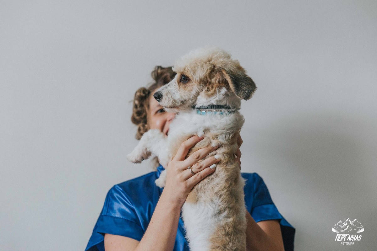 retrato de dia da noiva em que a noiva esta com sua cachorrinha no colo e sorrindo