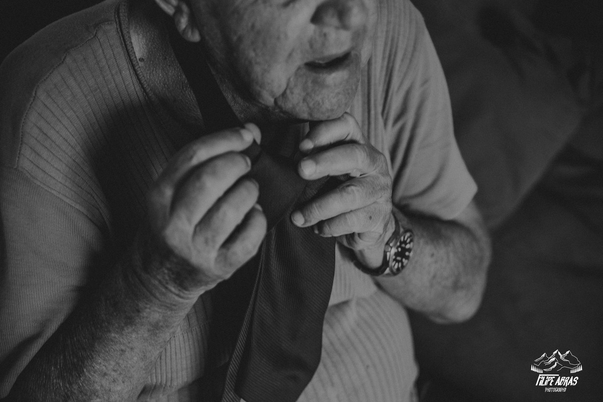 pai da noiva dando um nó na gravata em uma fotografia preto e branca de casamento