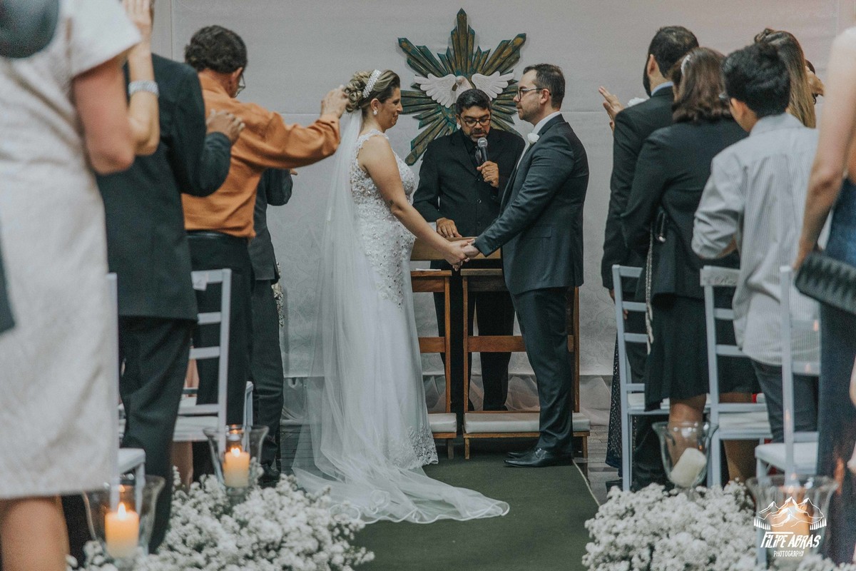 noivos olhando um para o outro durante a benção da igreja e do pastor