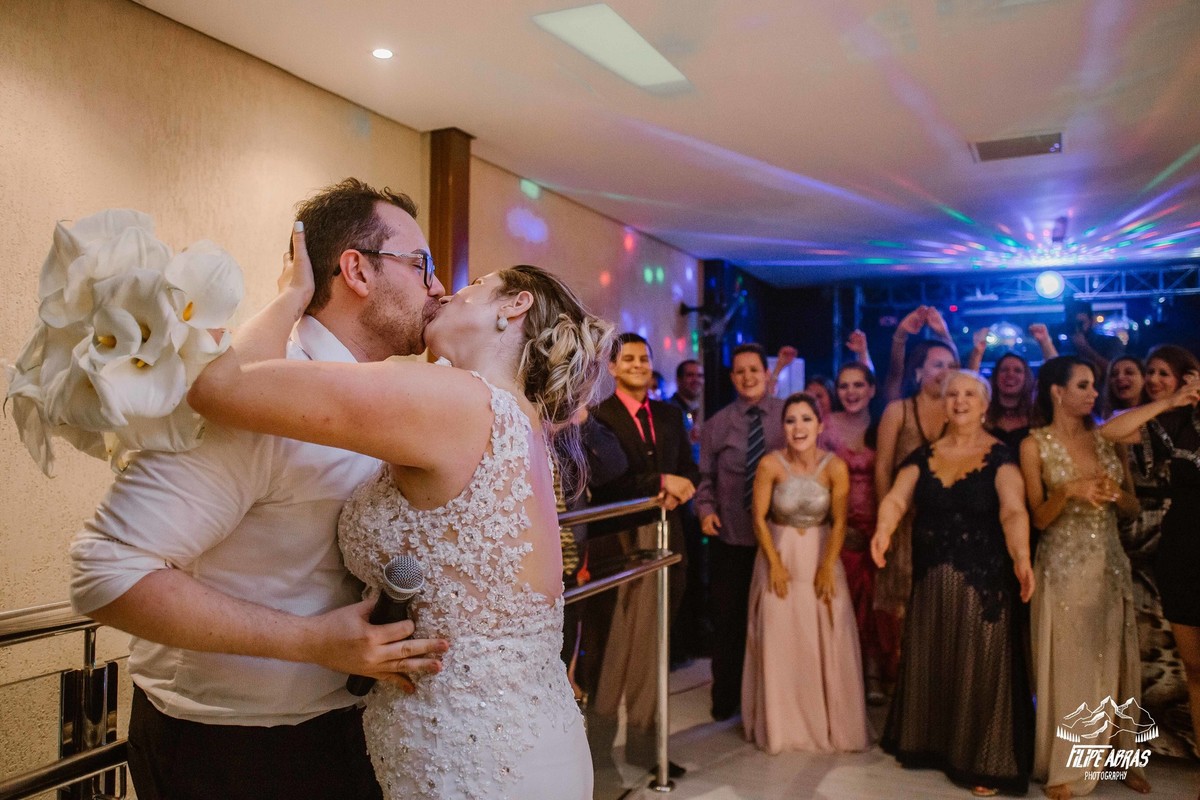 Noiva beijando o noivo antes de jogar o buque