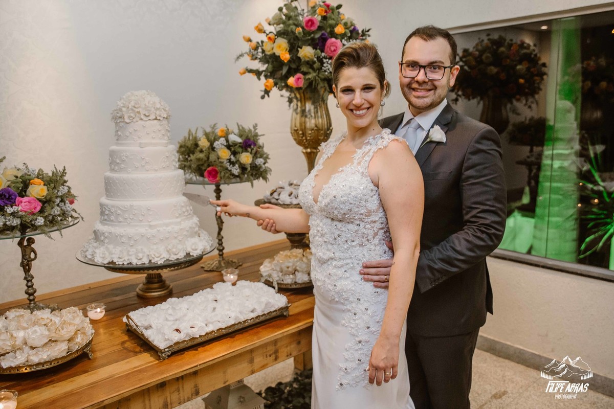 noivos cortando o bolo de casamento e sorrindo